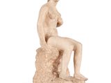 l'image d'une statue de femme assise sur un rocher
