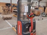 a forklift in a warehouse with a lot of wood