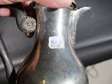 a person holding a silver pitcher with a sticker on it