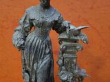 a statue of a woman holding a bird on a pedestal