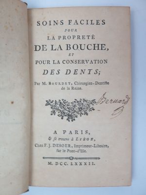 un livre ouvert avec une écriture dessus, posé sur une table