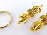 un gros plan sur deux bagues en or et une paire de boucles d'oreilles