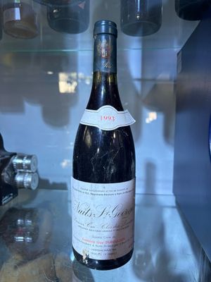 a bottle of wine sitting on a counter in a glass case