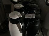a lot of coffee pots and cups on the counter