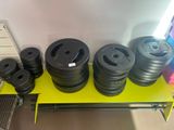 a lot of black dumbs on a yellow shelf
