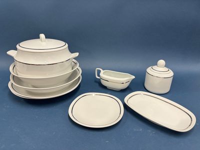 a lot of white dishes and cups on the table