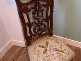 a chair that has a cushion on it in the corner of a room