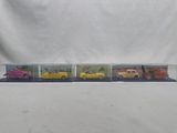 four toy cars are lined up in a row on a white background