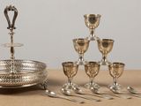 un plateau en argent avec des tasses et des cuillères en argent posées sur une table