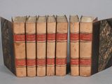 several old books are stacked on top of each other on a table