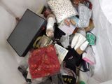 a white trash can filled with various items that include shoes, bags, and other items