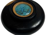 un bol noir avec une pierre bleue au centre