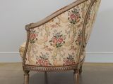 an old fashioned chair with a floral upholstered back and wooden legs