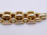 a close up of a bracelet with gold bells on a white surface