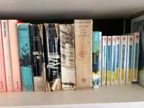 many books that are on a shelf in the room
