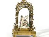 a figurine of a man and a woman in a gold frame