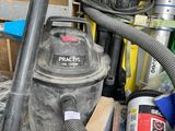 un aspirateur posé à côté d'un tas d'outils