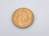 a close up of a gold coin on a white surface