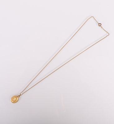 gros plan d'un collier en or sur une surface blanche