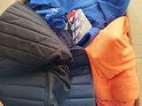 a cardboard box filled with clothes and blankets on the floor