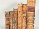 plusieurs vieux livres sont alignés sur une surface blanche