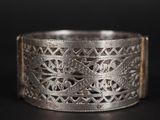 gros plan d'une bague en argent sur une surface noire
