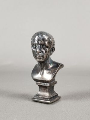 un gros plan sur une statue en argent représentant la tête d'un homme