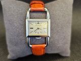 une photo d'une montre-bracelet posée sur un coussin, sur une table