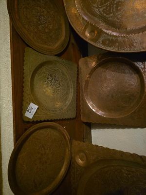 de nombreux types d'assiettes et de casseroles accrochés au mur