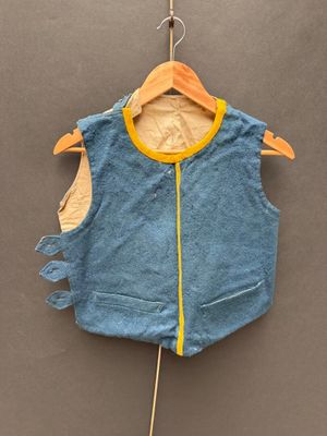 un gilet bleu accroché à un cintre sur un mur