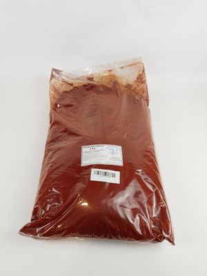 un sachet de poudre rouge posé sur une surface blanche