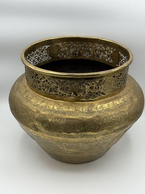 un vase en or posé sur une surface blanche