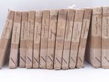 several old books stacked on top of each other on a white surface