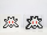 two black and white squares with red eyes are sitting on a table