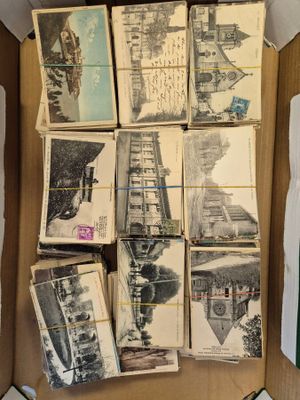 quelques vieilles cartes postales dans une boîte en carton posée sur une table