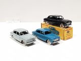 three toy cars sitting next to each other on a white surface