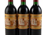 trois bouteilles de vin rouge posées l'une à côté de l'autre sur une surface blanche