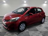 the red toyota yaris is parked in a large room