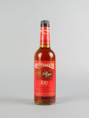 une image représentant une bouteille de vin rouge posée sur une surface blanche