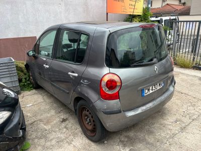 une voiture argentée garée sur un parking à côté d'une moto