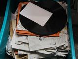 a plastic container filled with newspapers and a black record