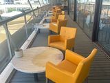 de nombreuses chaises et tables sur le pont d'un bateau de croisière