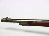 a close up of a rifle with a wooden barrel on a white background