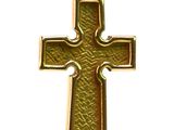 une croix en or suspendue à un cordon noir sur fond blanc