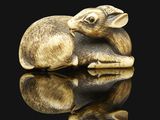 a small elephant figurine sitting on a black surface