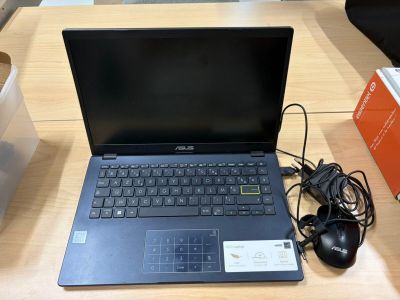 un ordinateur portable posé sur une table avec une souris