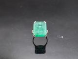 a close up of a ring with an emerald stone in it