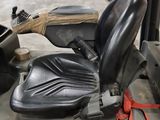 a black seat on a forklift in a warehouse