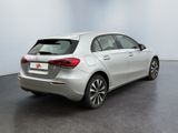 the rear end of a silver car in a white room