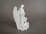 a white figurine of an angel with a bird on it ' s back